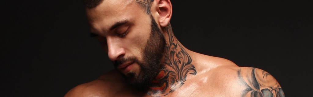 A man with a beard and tattoos on his neck.